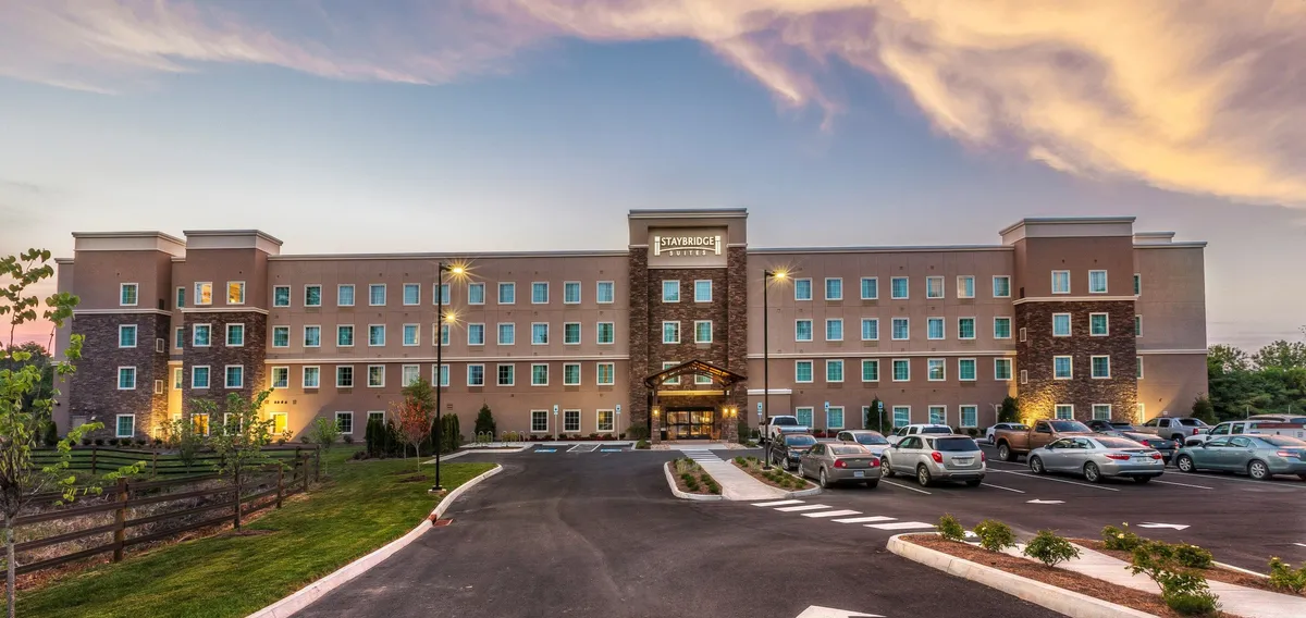 The hotel's main entrance, framed by neat landscaping and a spacious parking area, conveys a sense of ease and welcome for arriving families. The exterior setting implies convenient access to nearby Knoxville attractions and provides a visual cue to the property’s family-friendly atmosphere.